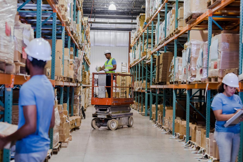 Distribution warehouse with worker on scissor lift.